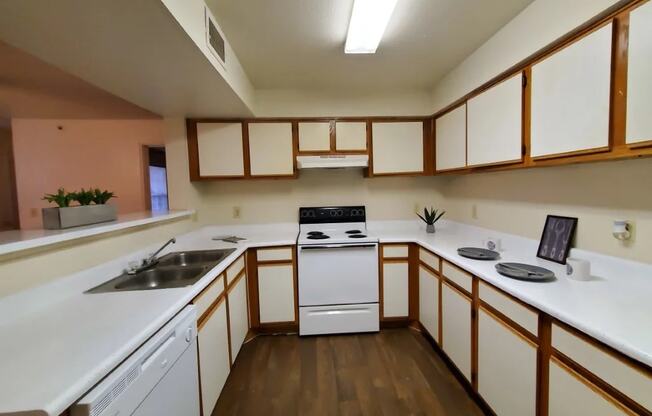 a kitchen with white countertops and wooden cabinets at GABLE HILLS Apartments, TULSA ,74127