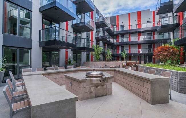 an outdoor patio with a fire pit in front of an apartment building