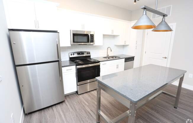 a kitchen with stainless steel appliances and a table at Century Baxter Avenue, Louisville, KY 40204