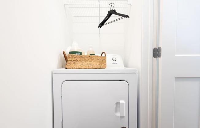 A white washing machine with a basket on top of it.