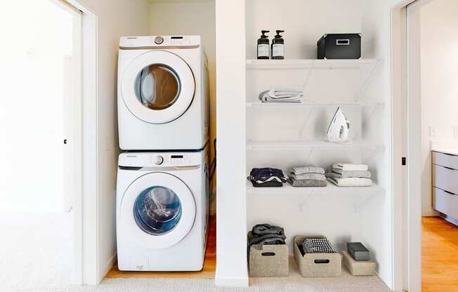a white washer and dryer in a white laundry room