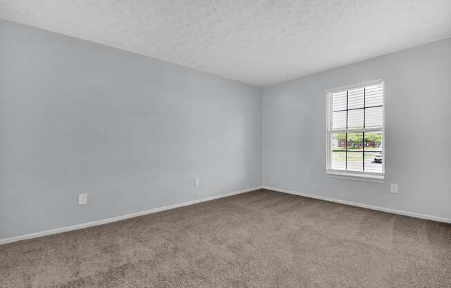 a bedroom with gray walls and a window