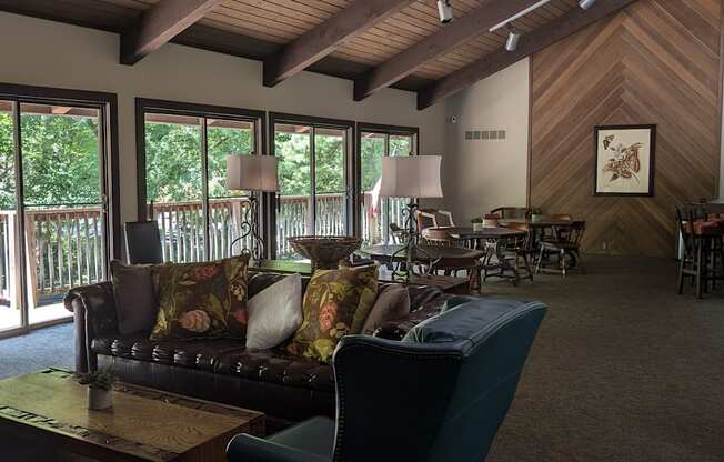a living room with couches and a table with chairs and a balcony