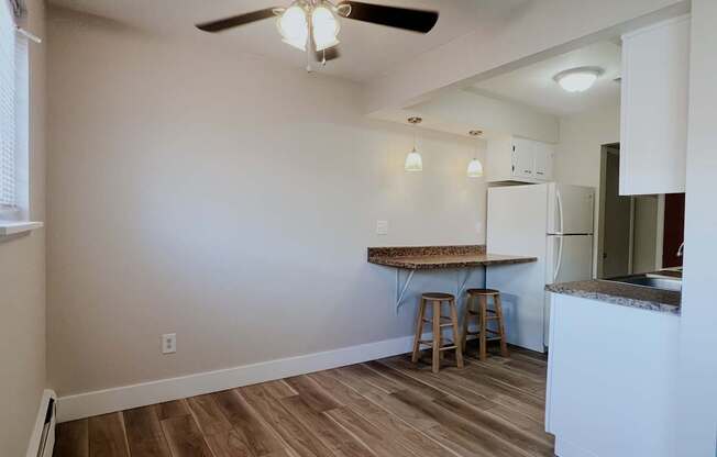 A kitchen with a table and bar stools.