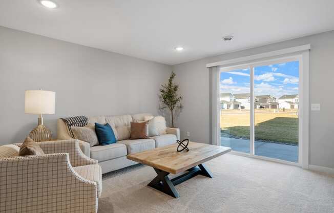 a living room with a couch and a coffee table in front of a window