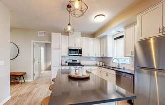 a kitchen with white cabinets and stainless steel appliances