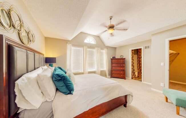 a bedroom with a large bed and a ceiling fan