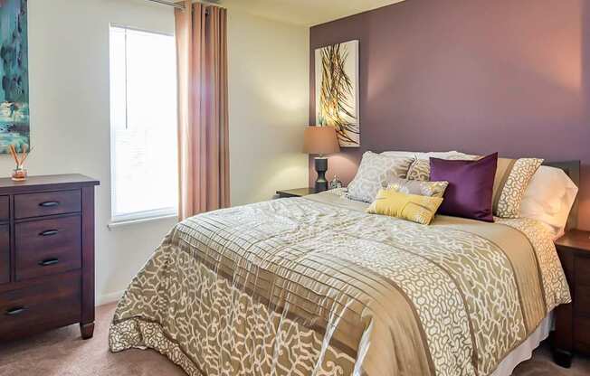 A bedroom with a large bed and a dresser.