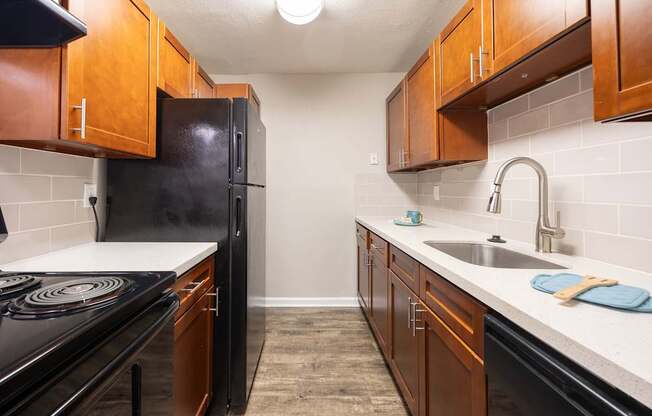 A kitchen with black appliances and wooden cabinets.