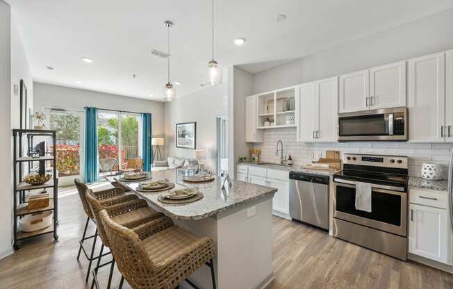 a kitchen with stainless steel appliances and a table with chairs