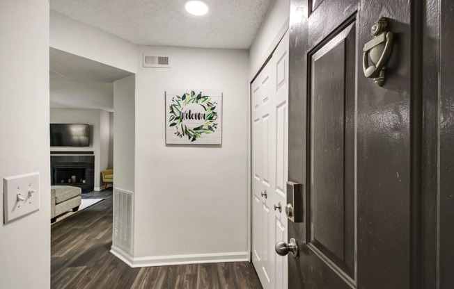 a hallway with a door and a living room with a fireplace at Timberwalk at Mandarin Apartment Homes, Florida, 32257