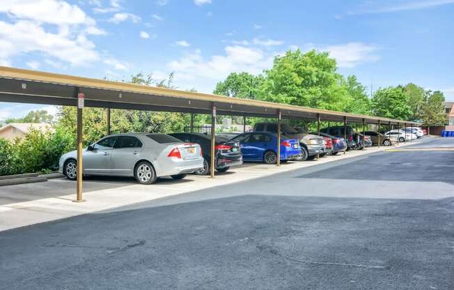 A parking lot with cars parked under a covered walkway.