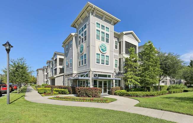 A large, modern building with a green lawn in front.