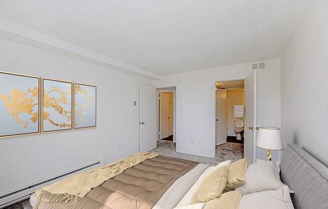 A bedroom with a bed, a lamp, and a map on the wall.