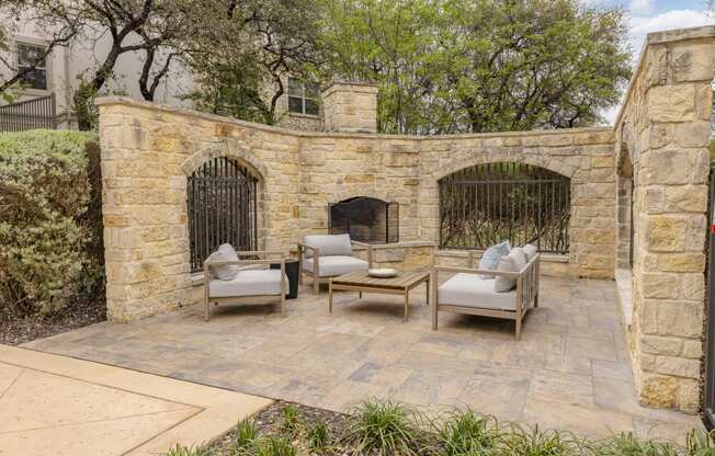 the backyard has a stone wall and a fireplace