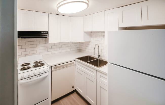 a white kitchen with white appliances and white cabinets