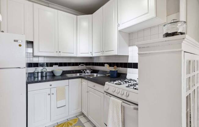 a white kitchen with white appliances and white cabinets at The Bryant at Oak Park I & II, Illinois