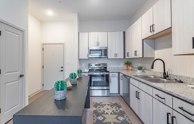 a kitchen with white cabinets and gray countertops