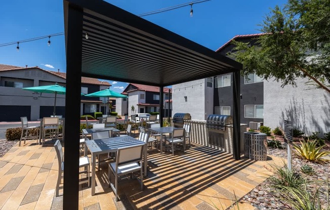 A patio with a table and chairs under a black awning.