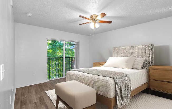A bedroom with a bed, a chair, and a window.