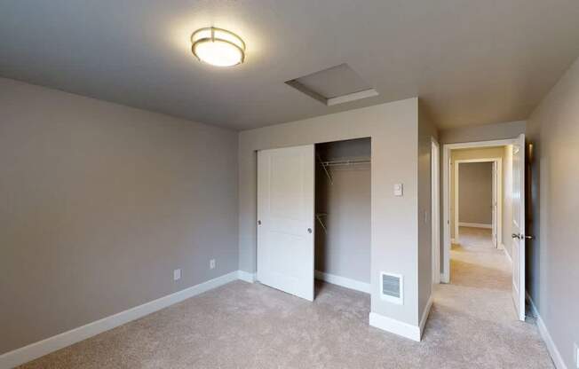 A room with a carpeted floor and a ceiling fan.