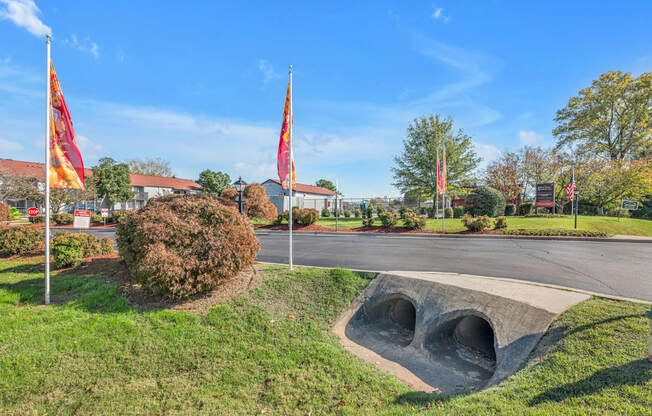 A park with a large concrete structure and flags.