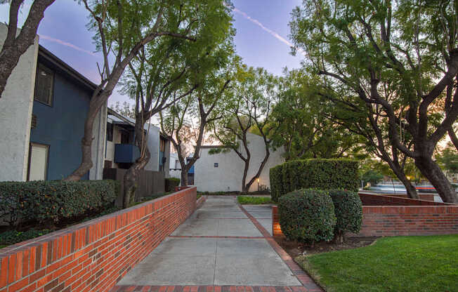 A residential street with a sidewalk and trees.