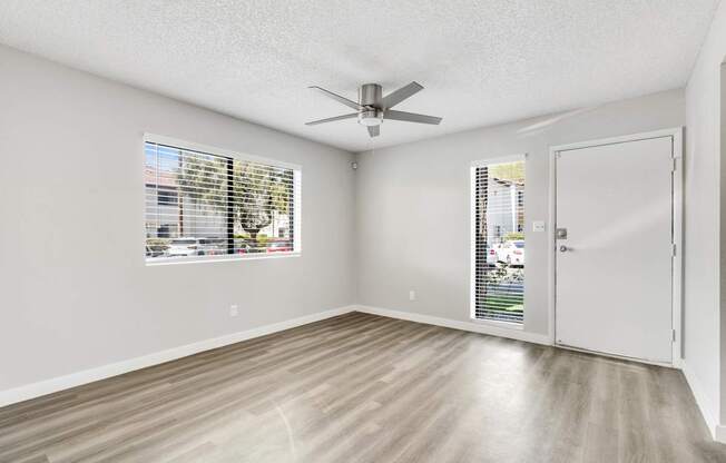 A room with a ceiling fan and a door leading to a balcony.