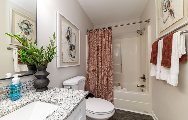 Bright bathroom with granite counters and bathtub