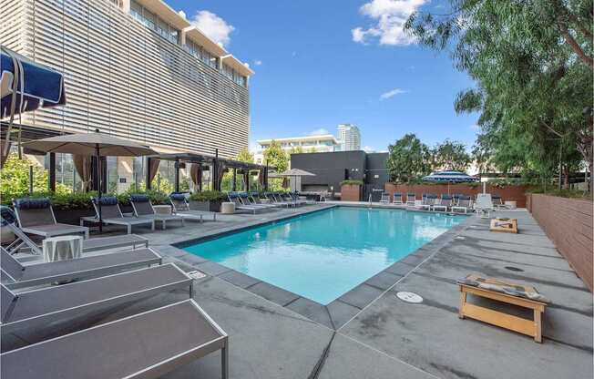 a swimming pool with lounge chairs and a building in the background