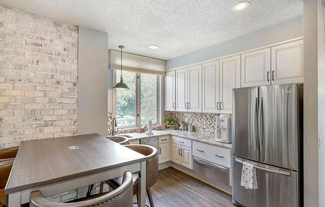 a kitchen with stainless steel appliances and a table and chairs