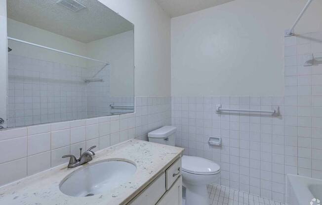 A white bathroom with a sink, toilet, and bathtub.