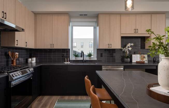 A kitchen with black countertops and wooden cabinets.