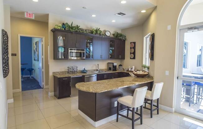 A kitchen with a granite counter top and a bar stool.