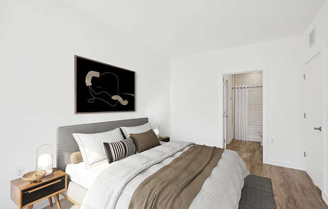 Model Bedroom with Wood-Style Flooring and attached Bathroom at Stella Apartments located in New Carrollton, MD.