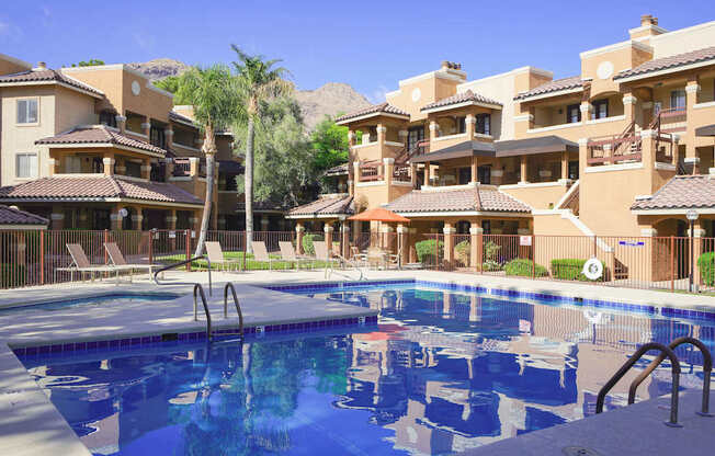 A large swimming pool in front of apartment buildings.