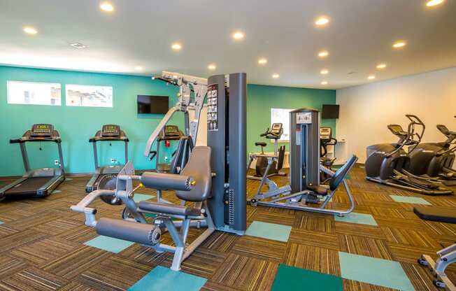 a gym with cardio equipment and weights in a wellness center at Skyview Apartments, Westminster Colorado