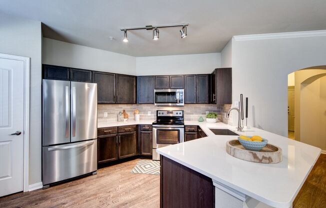 a kitchen with stainless steel appliances and a white counter top