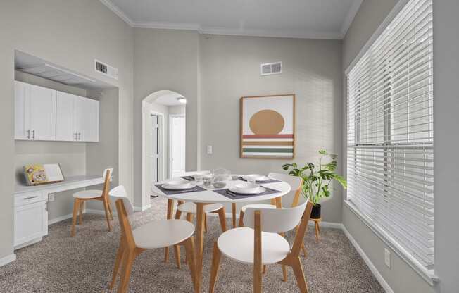 a dining room with a table and chairs and a large window