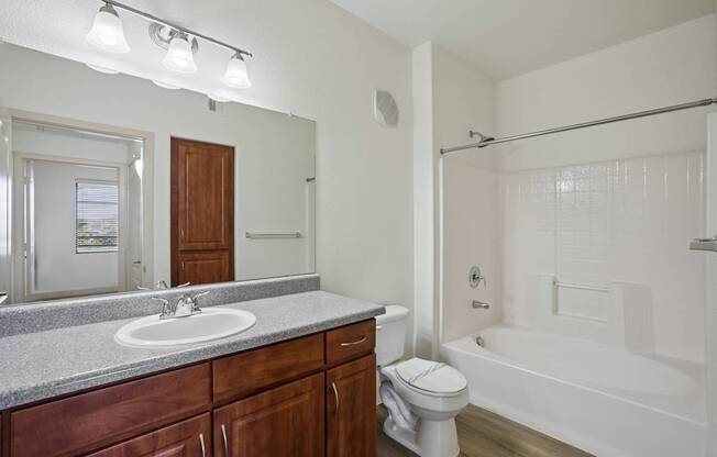 A bathroom with a white tub, sink, and toilet.