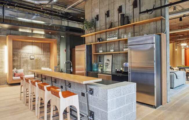 a kitchen with a counter and chairs in a restaurant