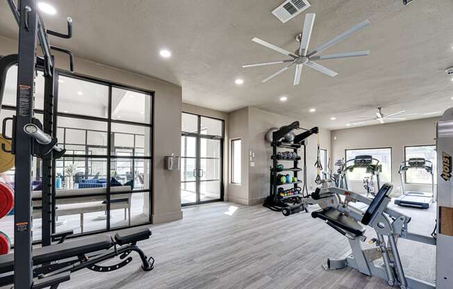 a home gym with a large window and a ceiling fan
