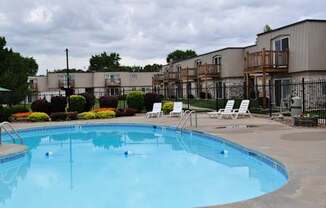 Poolside area with lounge chairs and shaded spots at Park 25 Apartments, providing a relaxing outdoor space.
