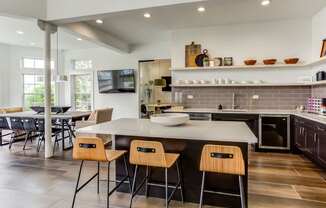 a kitchen with a center island and chairs in front of a table