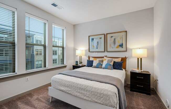 a bedroom with a large bed and three windows at Preston Ridge, Cary, 27513