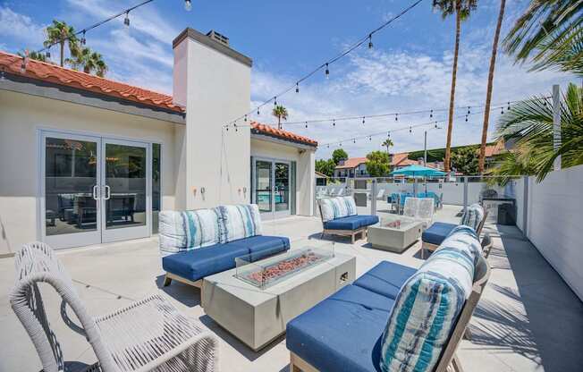 a patio with blue lounge chairs and a fire pit  at Laguna Gardens Apts., California