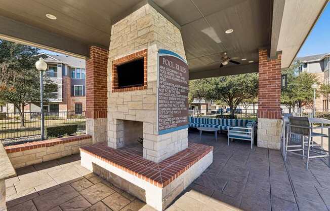 A brick fireplace with a sign that says pool rules.
