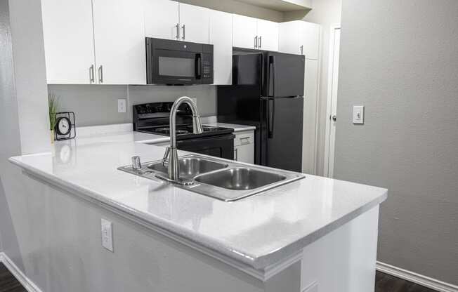 an empty kitchen with a sink and a refrigerator