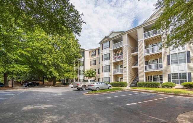A parking lot in front of a multi-story apartment building.