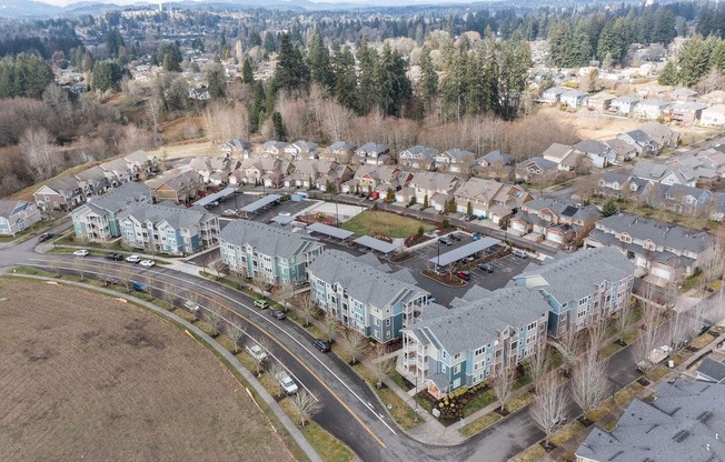 an aerial view of a neighborhood of houses with cars parked in front of them